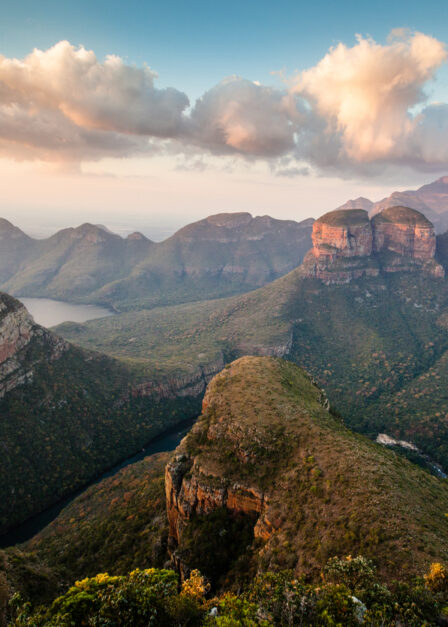 Blyde River Canyon à l’aube : les falaises rougeoyantes plongent dans la brume, révélant l’un des paysages les plus grandioses d’Afrique du Sud.