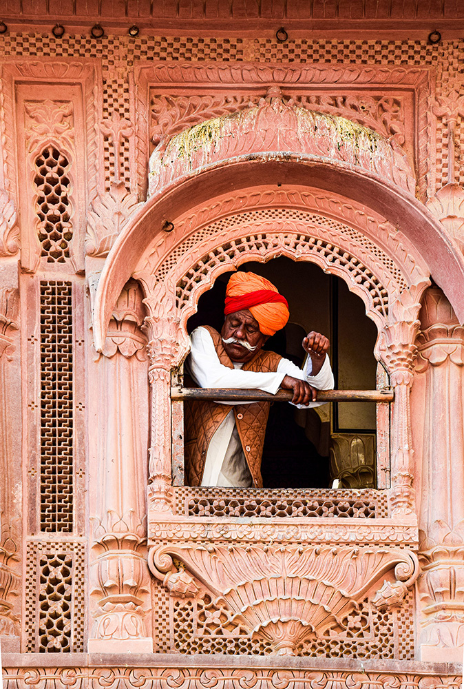 Un homme regarde à travers une fenêtre en Inde