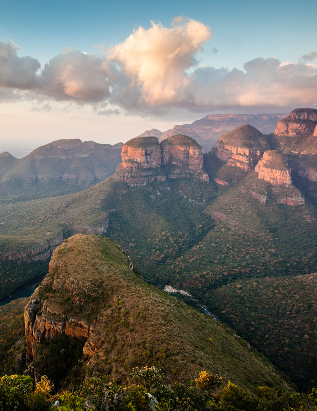 Blyde River Canyon à l’aube : les falaises rougeoyantes plongent dans la brume, révélant l’un des paysages les plus grandioses d’Afrique du Sud.