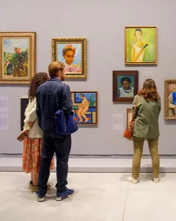 Personnes face à des tableaux à la Biennale de Venise en Italie