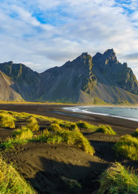 Vesturhorn Mountain in summer morning. Stokksnes, Iceland, Northern Europe, Scandinavia. Scenic beautiful nature landscape. Vibrant sunrise mountains landscape wallpaper. Popular tourist attraction.